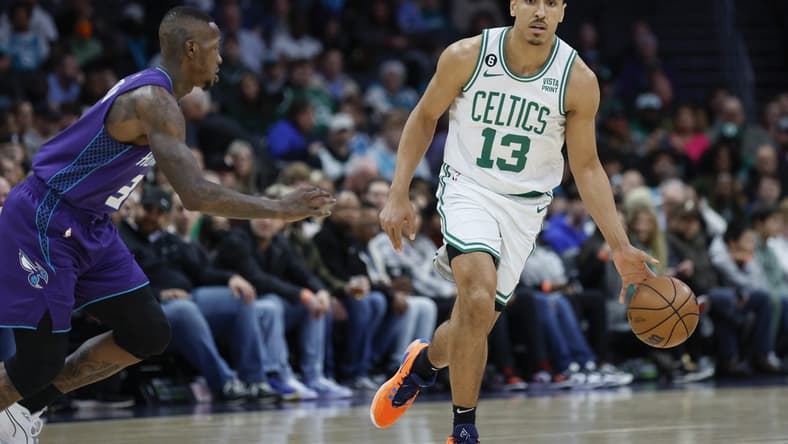 Jan 14, 2023; Charlotte, North Carolina, USA; Boston Celtics guard Malcolm Brogdon (13) controls the ball against Charlotte Hornets guard Terry Rozier (3) during the first half at Spectrum Center. Mandatory Credit: Nell Redmond-USA TODAY Sports