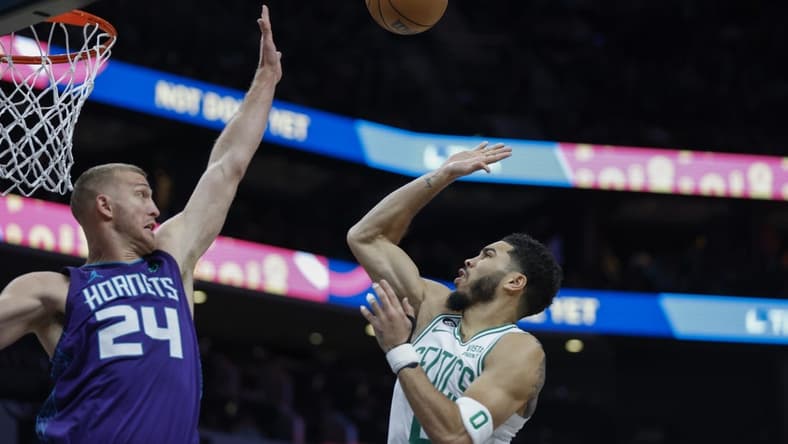 Jan 14, 2023; Charlotte, North Carolina, USA; Boston Celtics forward Jayson Tatum (0) shoots over Charlotte Hornets center Mason Plumlee (24) during the first half at Spectrum Center. Mandatory Credit: Nell Redmond-USA TODAY Sports