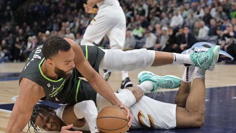 Jan 14, 2023; Minneapolis, Minnesota, USA; Minnesota Timberwolves center Rudy Gobert (27) and Cleveland Cavaliers forward Isaac Okoro (35) battle for a loose ball during the first quarter at Target Center. Mandatory Credit: Jeffrey Becker-USA TODAY Sports