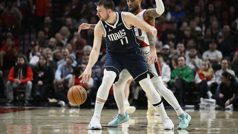 Jan 14, 2023; Portland, Oregon, USA; Dallas Mavericks guard Luka Doncic (77) dribbles the ball during the first half against Portland Trail Blazers guard Damian Lillard (0) at Moda Center. Mandatory Credit: Troy Wayrynen-USA TODAY Sports