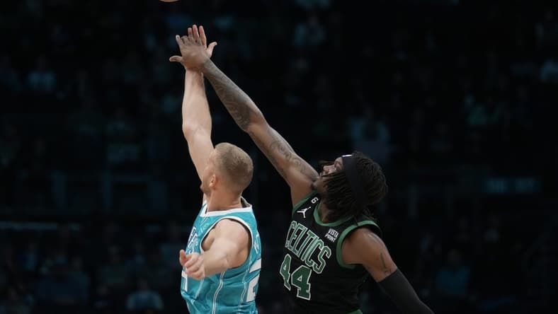 Jan 16, 2023; Charlotte, North Carolina, USA; Boston Celtics center Robert Williams III (44) gets the edge on the opening tip-off over Charlotte Hornets center Mason Plumlee (24) during the first quarter at Spectrum Center. Mandatory Credit: Jim Dedmon-USA TODAY Sports