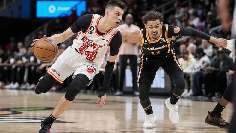 Jan 16, 2023; Atlanta, Georgia, USA; Miami Heat guard Tyler Herro (14) dribbles against Atlanta Hawks guard Trae Young (11) during the first half at State Farm Arena. Mandatory Credit: Dale Zanine-USA TODAY Sports