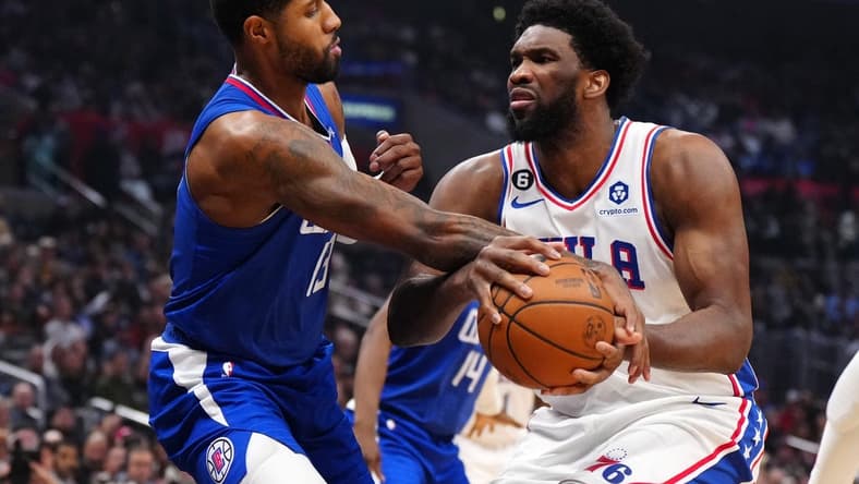 Jan 17, 2023; Los Angeles, California, USA; Philadelphia 76ers center Joel Embiid (21) is fouled by LA Clippers guard Paul George (13) in the first half at Crypto.com Arena. Mandatory Credit: Kirby Lee-USA TODAY Sports