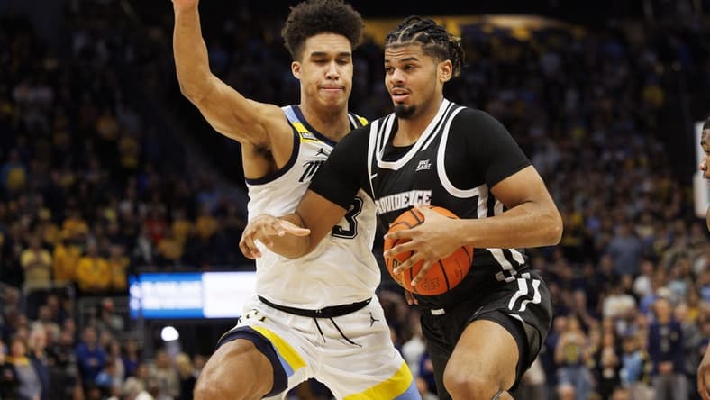 Jan 18, 2023; Milwaukee, Wisconsin, USA; Providence Friars forward Bryce Hopkins (23) drives for the basket against Marquette Golden Eagles forward Oso Ighodaro (13) during the first half at Fiserv Forum. Mandatory Credit: Jeff Hanisch-USA TODAY Sports