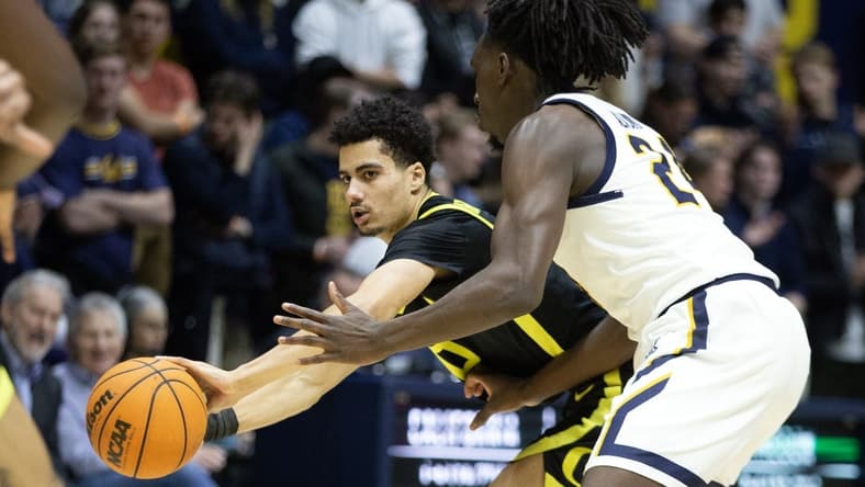 Jan 18, 2023; Berkeley, California, USA; Oregon Ducks guard Will Richardson (0) passes around California Golden Bears forward Sam Alajiki (24) during the first half at Haas Pavilion. Mandatory Credit: D. Ross Cameron-USA TODAY Sports
