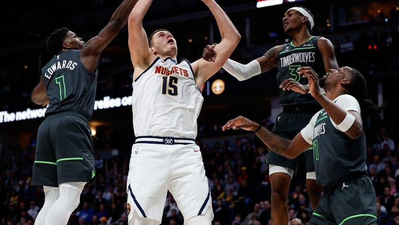 Jan 18, 2023; Denver, Colorado, USA; Denver Nuggets center Nikola Jokic (15) is fouled by Minnesota Timberwolves forward Jaden McDaniels (3) as he battles for a rebound with Minnesota Timberwolves guard Anthony Edwards (1) and center Naz Reid (11) in the second quarter at Ball Arena. Mandatory Credit: Isaiah J. Downing-USA TODAY Sports
