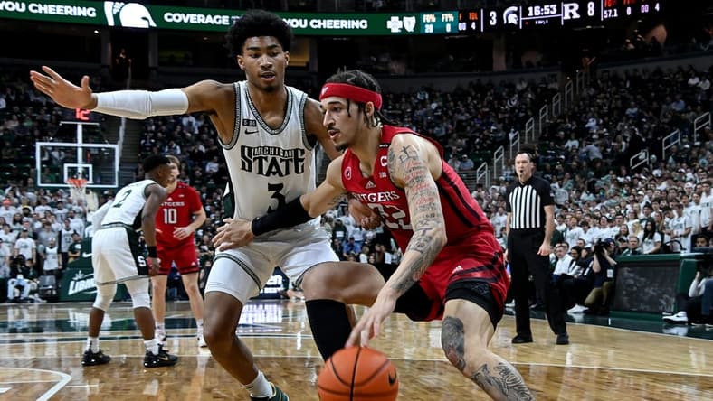 Jan 19, 2023; East Lansing, Michigan, USA; Rutgers Scarlet Knights guard Caleb McConnell (22) drives the baseline against Michigan State Spartans guard Jaden Akins (3) in the first half at Jack Breslin Student Events Center. Mandatory Credit: Dale Young-USA TODAY Sports