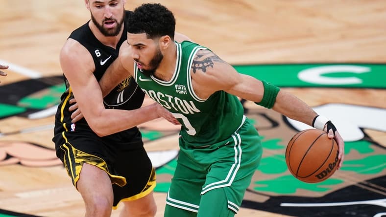 Jan 19, 2023; Boston, Massachusetts, USA; Boston Celtics forward Jayson Tatum (0) moves the ball against Golden State Warriors guard Klay Thompson (11) in the second quarter at TD Garden. Mandatory Credit: David Butler II-USA TODAY Sports