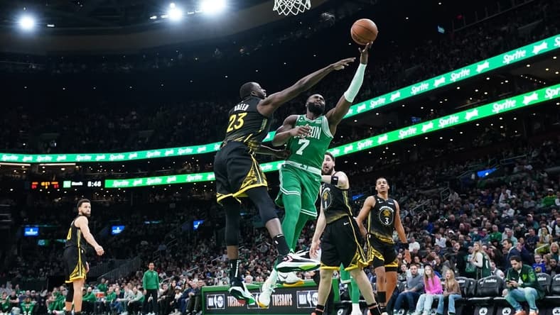Jan 19, 2023; Boston, Massachusetts, USA; Boston Celtics guard Jaylen Brown (7) shoots against Golden State Warriors forward Draymond Green (23) in the second half at TD Garden. Mandatory Credit: David Butler II-USA TODAY Sports
