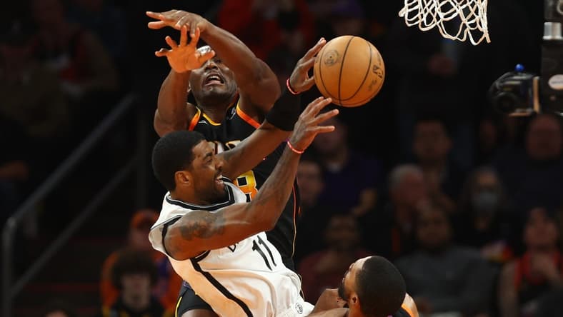 Jan 19, 2023; Phoenix, Arizona, USA; Brooklyn Nets guard Kyrie Irving (11) passes the ball against Phoenix Suns center Bismack Biyombo in the first half at Footprint Center. Mandatory Credit: Mark J. Rebilas-USA TODAY Sports