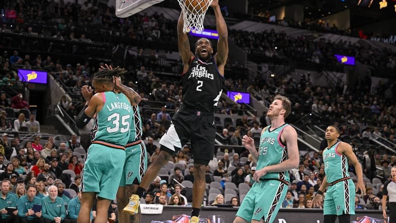 Jan 20, 2023; San Antonio, Texas, USA; LA Clippers forward Kawhi Leonard (2) dunks the ball past San Antonio Spurs guard Romeo Langford (35) and center Jakob Poeltl (25) during the first quarter at the AT&T Center. Mandatory Credit: Jerome Miron-USA TODAY Sports