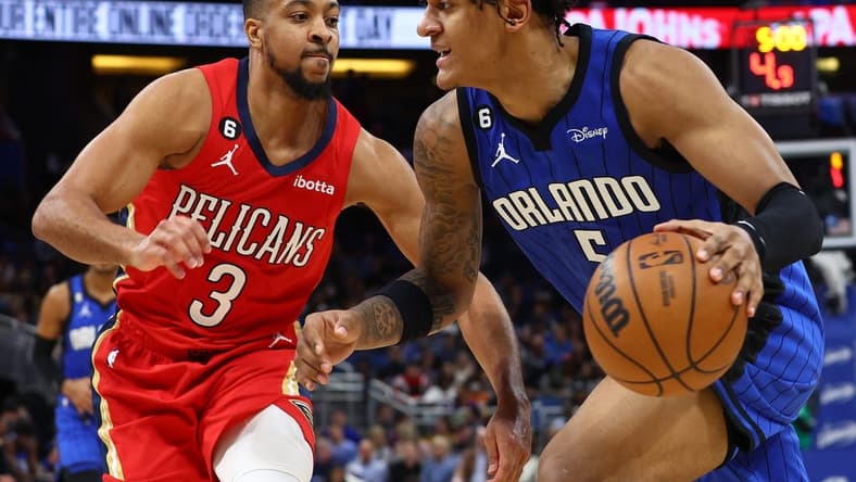 Jan 20, 2023; Orlando, Florida, USA; Orlando Magic forward Paolo Banchero (5) drives to the basket as New Orleans Pelicans guard CJ McCollum (3) defends during the second quarter at Amway Center. Mandatory Credit: Kim Klement-USA TODAY Sports