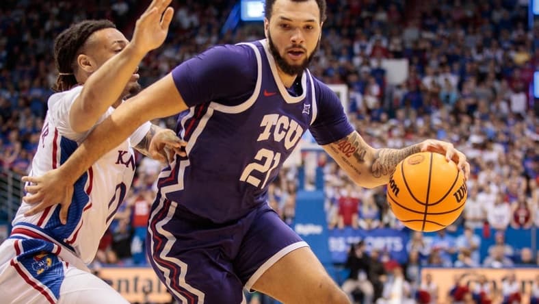 Jan 21, 2023; Lawrence, Kansas, USA; TCU Horned Frogs forward JaKobe Coles (21) drives around Kansas Jayhawks guard Bobby Pettiford Jr. (0) during the first half at Allen Fieldhouse. Mandatory Credit: William Purnell-USA TODAY Sports