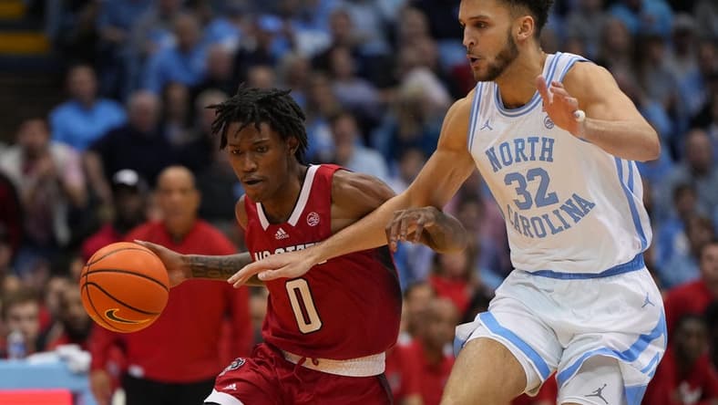 Jan 21, 2023; Chapel Hill, North Carolina, USA; North Carolina State Wolfpack guard Terquavion Smith (0) dribbles as North Carolina Tar Heels forward Pete Nance (32) defends in the first half at Dean E. Smith Center. Mandatory Credit: Bob Donnan-USA TODAY Sports