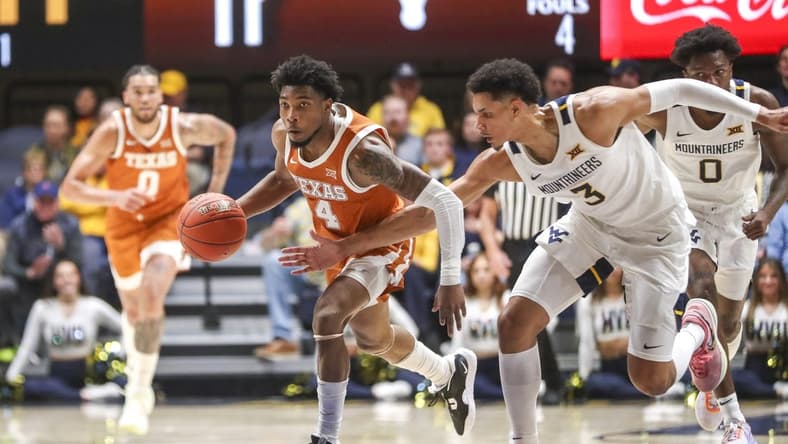 Jan 21, 2023; Morgantown, West Virginia, USA; Texas Longhorns guard Tyrese Hunter (4) steals a pass as West Virginia Mountaineers forward Tre Mitchell (3) defends during the first half at WVU Coliseum. Mandatory Credit: Ben Queen-USA TODAY Sports