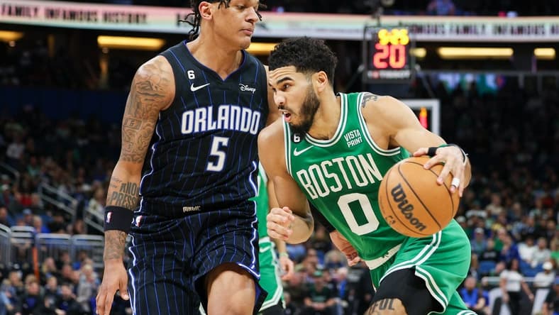 Jan 23, 2023; Orlando, Florida, USA; Boston Celtics forward Jayson Tatum (0) drives ti the basket past Orlando Magic forward Paolo Banchero (5) in the first quarter at Amway Center. Mandatory Credit: Nathan Ray Seebeck-USA TODAY Sports