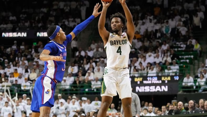 Jan 23, 2023; Waco, Texas, USA; Baylor Bears guard LJ Cryer (4) scores a three-point basket against Kansas Jayhawks guard Dajuan Harris Jr. (3) during the first half at Ferrell Center. Mandatory Credit: Chris Jones-USA TODAY Sports