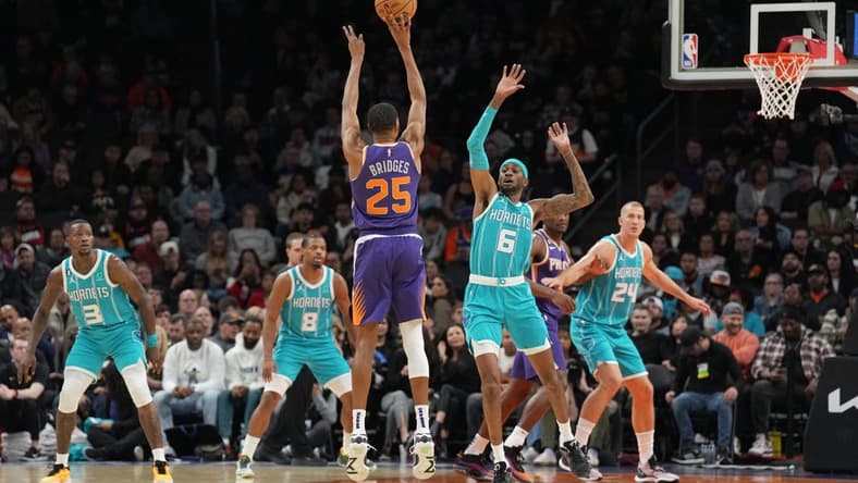 Jan 24, 2023; Phoenix, Arizona, USA; Phoenix Suns forward Mikal Bridges (25) shoots over Charlotte Hornets forward Jalen McDaniels (6) during the first half at Footprint Center. Mandatory Credit: Joe Camporeale-USA TODAY Sports