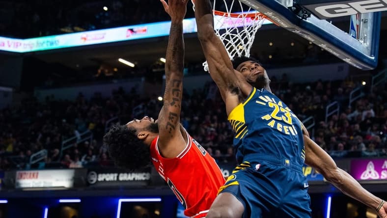 Jan 24, 2023; Indianapolis, Indiana, USA; Indiana Pacers forward Aaron Nesmith (23) blocks the shot of Chicago Bulls guard Coby White (0) in the second half at Gainbridge Fieldhouse. Mandatory Credit: Trevor Ruszkowski-USA TODAY Sports