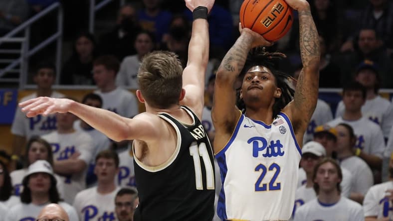 Jan 25, 2023; Pittsburgh, Pennsylvania, USA;  Pittsburgh Panthers guard Nike Sibande (22) shoots a three point basket against Wake Forest Demon Deacons forward Andrew Carr (11) during the first half at the Petersen Events Center. Mandatory Credit: Charles LeClaire-USA TODAY Sports