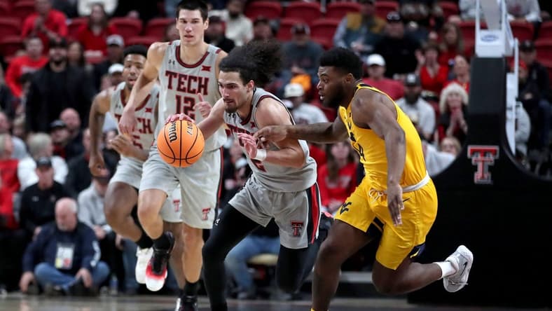 Jan 25, 2023; Lubbock, Texas, USA; Texas Tech Red Raiders guard Pop Isaacs (2) dribbles against West Virgina Mountaineers guard Seth Wilson (14) in the first half at United Supermarkets Arena. Mandatory Credit: Michael C. Johnson-USA TODAY Sports