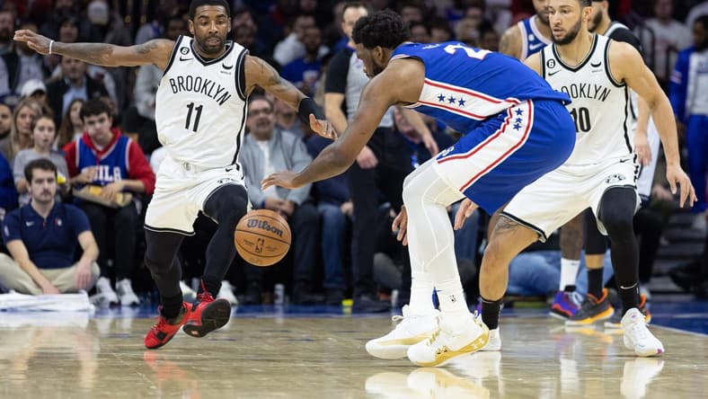 Jan 25, 2023; Philadelphia, Pennsylvania, USA; Philadelphia 76ers center Joel Embiid (21) controls a loose ball over Brooklyn Nets guard Kyrie Irving (11) and guard Ben Simmons (10) during the second quarter at Wells Fargo Center. Mandatory Credit: Bill Streicher-USA TODAY Sports