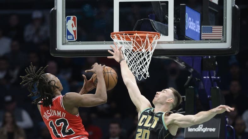 Jan 26, 2023; Charlotte, North Carolina, USA; Chicago Bulls guard Ayo Dosunmu (12) drives in as he is ended by Charlotte Hornets Gordon Hayward (20) during the first half at the Spectrum Center. Mandatory Credit: Sam Sharpe-USA TODAY Sports