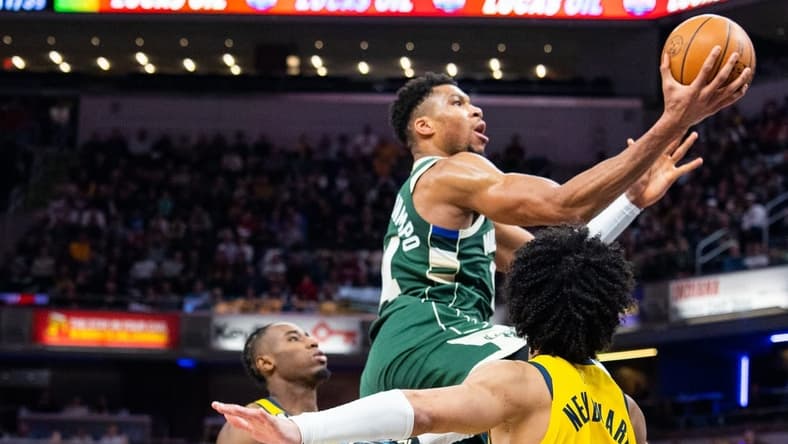 Jan 27, 2023; Indianapolis, Indiana, USA; Milwaukee Bucks forward Giannis Antetokounmpo (34) shoots the ball while Indiana Pacers guard Andrew Nembhard (2) defends in the second half at Gainbridge Fieldhouse. Mandatory Credit: Trevor Ruszkowski-USA TODAY Sports
