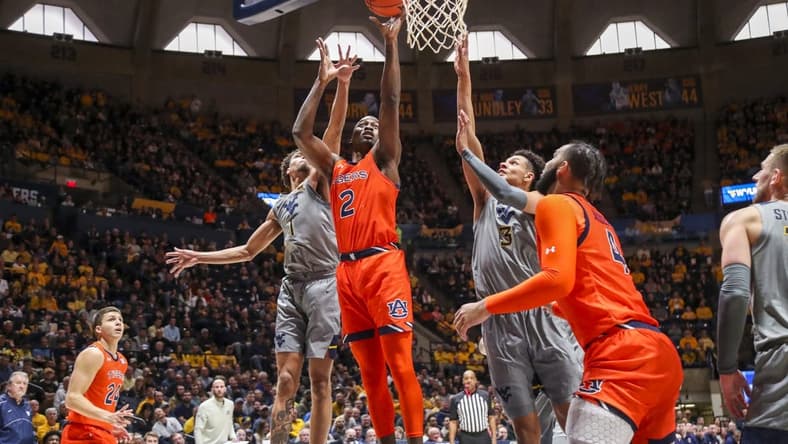 Jan 28, 2023; Morgantown, West Virginia, USA; Auburn Tigers forward Jaylin Williams (2) shoots in the lane against West Virginia Mountaineers forward Emmitt Matthews Jr. (1) and forward Tre Mitchell (3) during the first half at WVU Coliseum. Mandatory Credit: Ben Queen-USA TODAY Sports