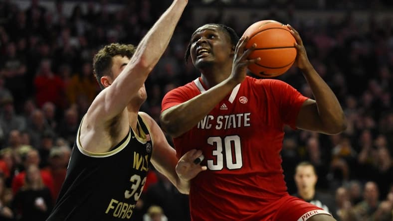 Jan 28, 2023; Winston-Salem, North Carolina, USA; North Carolina State Wolfpack forward D.J. Burns Jr. (30) shoots over Wake Forest Demon Deacons forward Matthew Marsh (33) during the second half at Lawrence Joel Veterans Memorial Coliseum. Mandatory Credit: William Howard-USA TODAY Sports