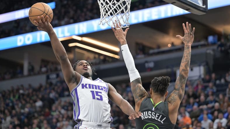 Jan 28, 2023; Minneapolis, Minnesota, USA; Sacramento Kings guard Davion Mitchell (15) goes to the basket as Minnesota Timberwolves guard D'Angelo Russell (0) defends during the second quarter at Target Center. Mandatory Credit: Jeffrey Becker-USA TODAY Sports