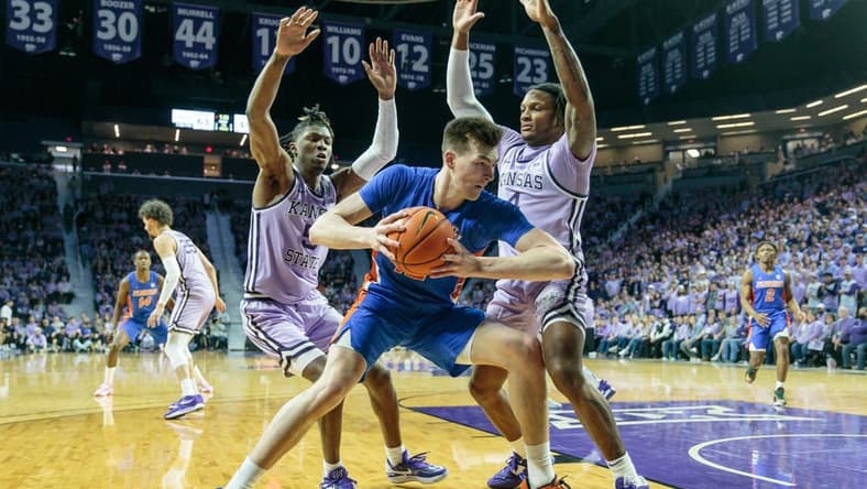 Jan 28, 2023; Manhattan, Kansas, USA; Florida Gators forward Colin Castleton (12) tries to drive the baseline around Kansas State Wildcats guard Cam Carter (5) and Kansas State Wildcats guard Tykei Greene (4) during the second half at Bramlage Coliseum. Mandatory Credit: William Purnell-USA TODAY Sports