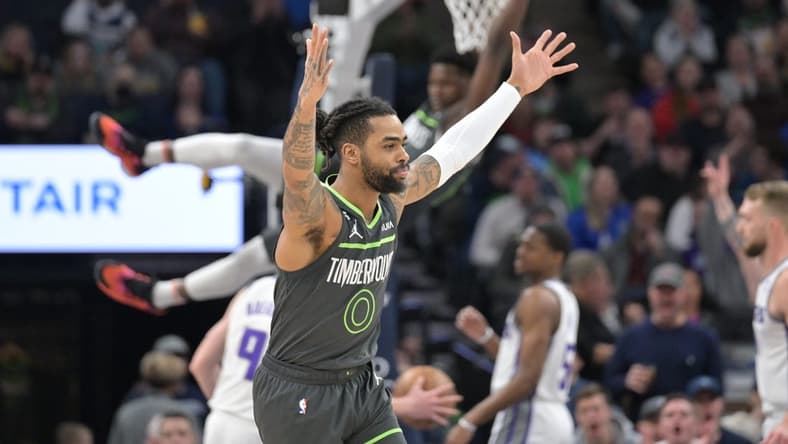 Jan 28, 2023; Minneapolis, Minnesota, USA; Minnesota Timberwolves guard D'Angelo Russell (0) reacts as guard Anthony Edwards (1) hangs from the rim against the Sacramento Kings during the first quarter at Target Center. Mandatory Credit: Jeffrey Becker-USA TODAY Sports