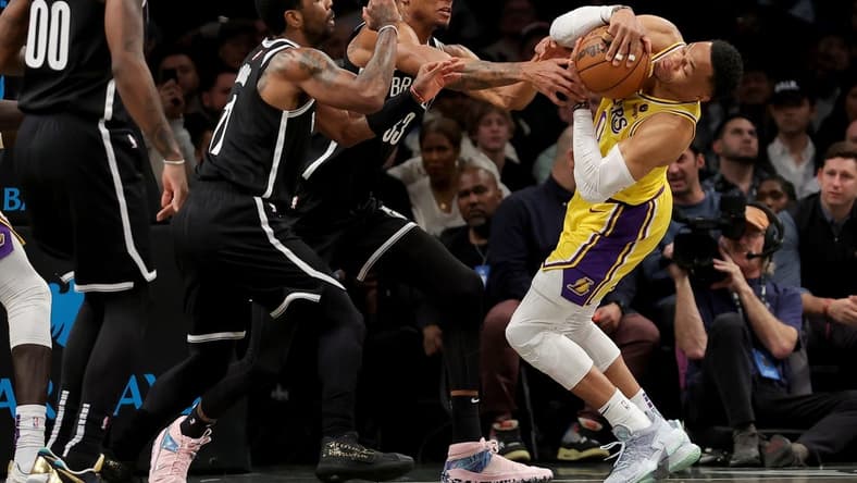 Jan 30, 2023; Brooklyn, New York, USA; Los Angeles Lakers guard Russell Westbrook (0) fights for the ball against Brooklyn Nets guard Kyrie Irving (11) and center Nic Claxton (33) during the first quarter at Barclays Center. Mandatory Credit: Brad Penner-USA TODAY Sports