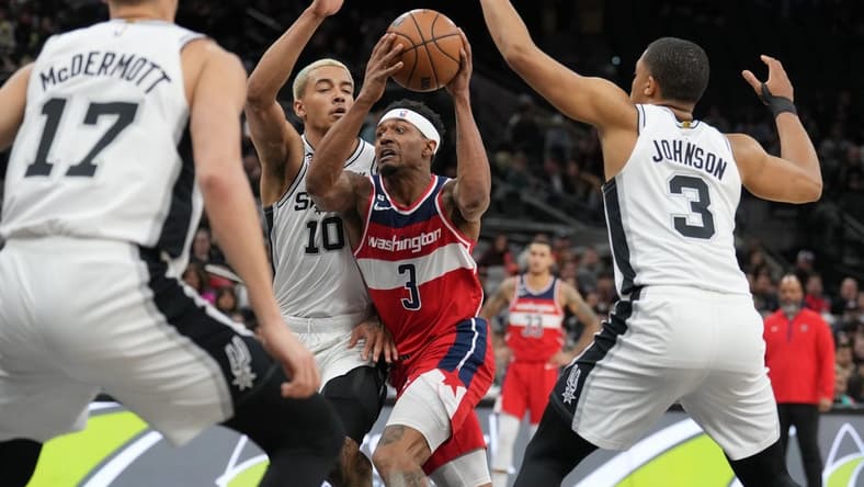 Jan 30, 2023; San Antonio, Texas, USA; Washington Wizards guard Bradley Beal (3) drives between San Antonio Spurs forwards Jeremy Sochan (10) and Keldon Johnson (3) in the first half at the AT&T Center. Mandatory Credit: Daniel Dunn-USA TODAY Sports