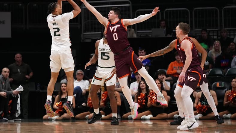 Jan 31, 2023; Coral Gables, Florida, USA; Miami Hurricanes guard Isaiah Wong (2) attempts a three point shot over Virginia Tech Hokies guard Hunter Cattoor (0) during the first half at Watsco Center. Mandatory Credit: Jasen Vinlove-USA TODAY Sports