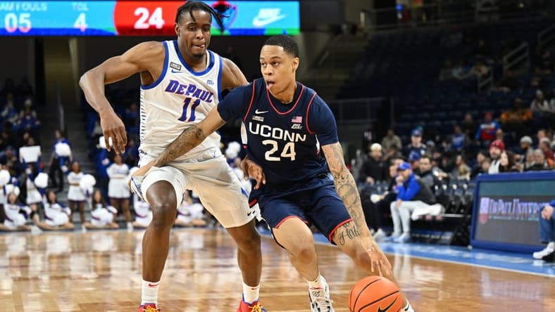 Jan 31, 2023; Chicago, Illinois, USA; Connecticut Huskies guard Jordan Hawkins (24) drives to the basket around DePaul Blue Demons forward Eral Penn (11) in the first half at Wintrust Arena. Mandatory Credit: Jamie Sabau-USA TODAY Sports
