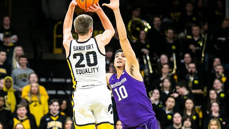 Iowa forward Payton Sandfort (20) makes a 3-point basket as Northwestern forward Tydus Verhoeven (10) defends during a NCAA Big Ten Conference men's basketball game, Tuesday, Jan. 31, 2023, at Carver-Hawkeye Arena in Iowa City, Iowa.
230131 N Western Iowa Mbb 034 Jpg
