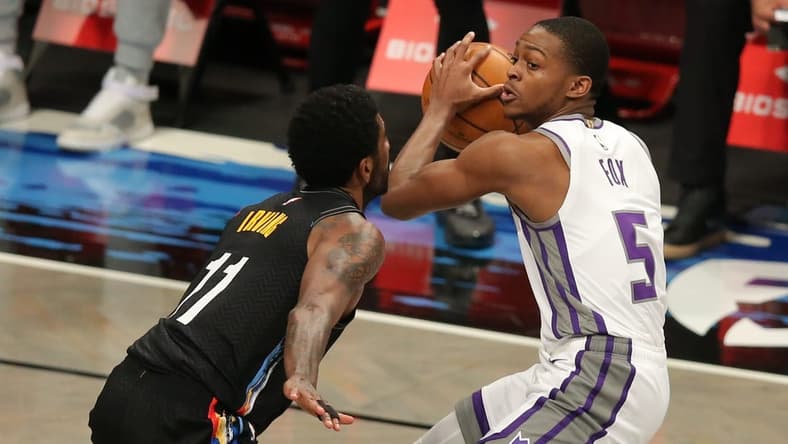 Feb 23, 2021; Brooklyn, New York, USA; Sacramento Kings point guard De'Aaron Fox (5) controls the ball against Brooklyn Nets point guard Kyrie Irving (11) during the third quarter at Barclays Center. Mandatory Credit: Brad Penner-USA TODAY Sports
