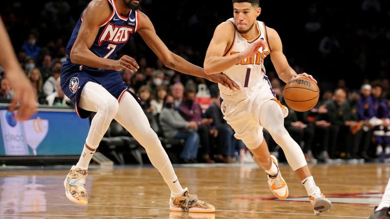 Nov 27, 2021; Brooklyn, New York, USA; Phoenix Suns guard Devin Booker (1) drives with the ball around Brooklyn Nets forward Kevin Durant (7) during the first quarter at Barclays Center. Mandatory Credit: Brad Penner-USA TODAY Sports