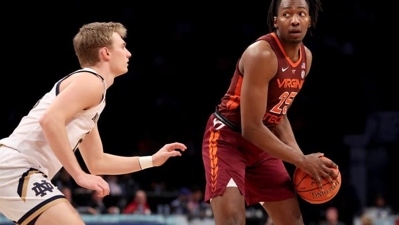 Mar 10, 2022; Brooklyn, NY, USA; Virginia Tech Hokies forward Justyn Mutts (25) controls the ball against Notre Dame Fighting Irish guard Dane Goodwin (23) during the second half at Barclays Center. Mandatory Credit: Brad Penner-USA TODAY Sports