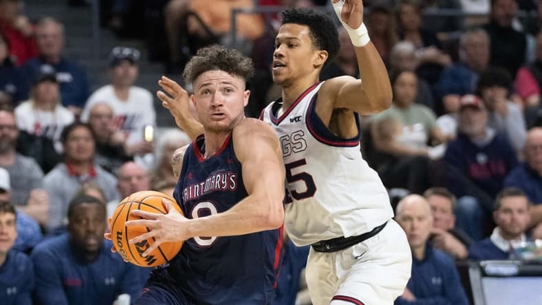 March 8, 2022; Las Vegas, NV, USA; Saint Mary's Gaels guard Logan Johnson (0) dribbles the basketball against Gonzaga Bulldogs guard Rasir Bolton (45) during the second half in the finals of the WCC Basketball Championships at Orleans Arena. Mandatory Credit: Kyle Terada-USA TODAY Sports
