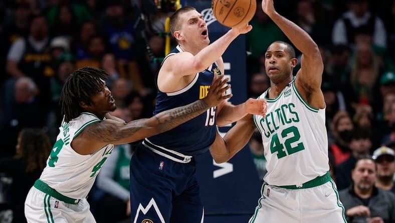 Mar 20, 2022; Denver, Colorado, USA; Denver Nuggets center Nikola Jokic (15) looks to pass the ball under pressure from Boston Celtics center Robert Williams III (44) and center Al Horford (42) in the first quarter at Ball Arena. Mandatory Credit: Isaiah J. Downing-USA TODAY Sports