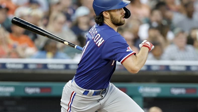 Jun 17, 2022; Detroit, Michigan, USA; Texas Rangers third baseman Charlie Culberson (11) hits an RBI single in the sixth inning against the Detroit Tigers at Comerica Park. Mandatory Credit: Rick Osentoski-USA TODAY Sports