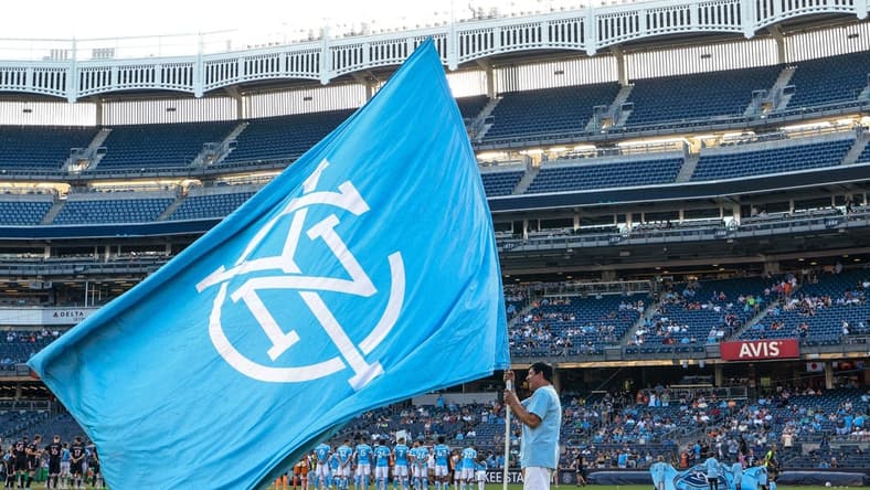 Jul 23, 2022; New York, New York, USA; A fan holds a NYCFC flag on the pitch before a match between New York City FC and Inter Miami CF at Yankee Stadium. Mandatory Credit: Vincent Carchietta-USA TODAY Sports