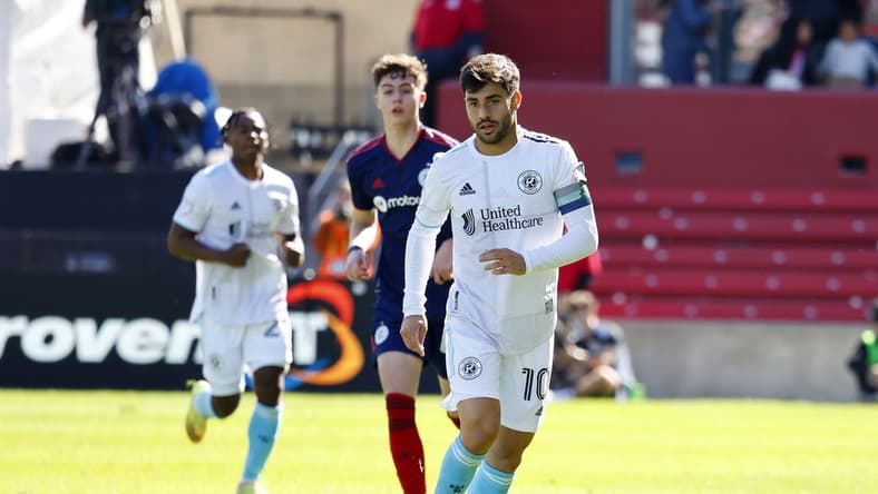 Oct 9, 2022; Chicago, Illinois, USA; New England Revolution midfielder Carles Gil (10) kicks the ball against the Chicago Fire during the first half at Bridgeview Stadium. Mandatory Credit: Mike Dinovo-USA TODAY Sports