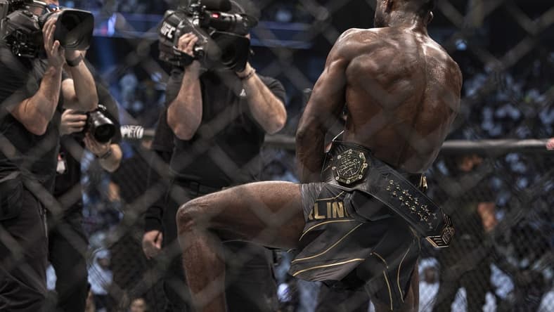 Oct 22, 2022; Abu Dhabi, UAE; Aljamain Sterling (red gloves) celebrates with the title belt after defeating T.J. Dillashaw (blue gloves) during UFC 280 at Etihad Arena. Mandatory Credit: Craig Kidwell-USA TODAY Sports