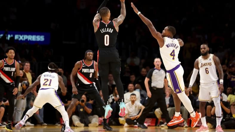Oct 23, 2022; Los Angeles, California, USA;  Portland Trail Blazers guard Damian Lillard (0) shoots a three-pointer against Los Angeles Lakers guard Lonnie Walker IV (4) during the fourth quarter at Crypto.com Arena. Mandatory Credit: Kiyoshi Mio-USA TODAY Sports