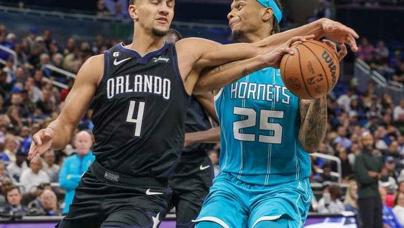Nov 14, 2022; Orlando, Florida, USA; Orlando Magic guard Jalen Suggs (4) defends Charlotte Hornets forward P.J. Washington (25) during the second quarter at Amway Center. Mandatory Credit: Mike Watters-USA TODAY Sports