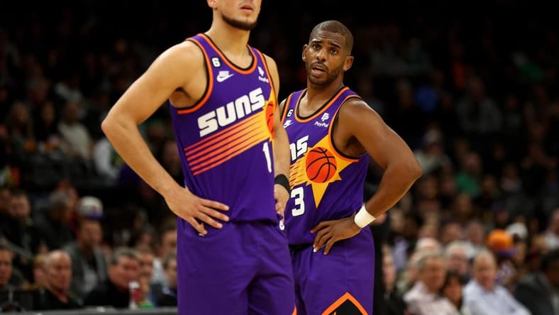 Dec 7, 2022; Phoenix, Arizona, USA; Phoenix Suns guard Devin Booker (1) and Chris Paul (3) against the Boston Celtics at Footprint Center. Mandatory Credit: Mark J. Rebilas-USA TODAY Sports